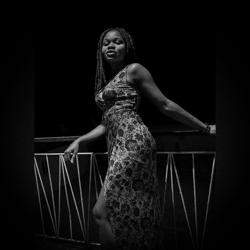 A black and white picture of an African girl in the dark